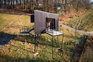 a small house on sticks in a field at Treeangle - K1 Baumhaus in Odenthal +8 photos