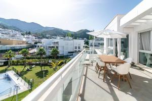 ベナアビスにあるCasa Ana Benahavisのテーブルと椅子があり、街の景色が見えるバルコニー