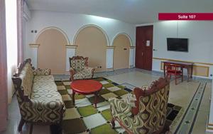 a living room with chairs and a table and a tableablish at HOTEL LE MAJESTIC in Douala