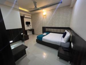 a bedroom with a bed and a television in it at Western Keys Hotel in Bangalore