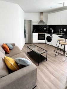 a living room with a couch and a kitchen at Modern City Centre Two Bedroom Windsor Apartment - Grand Central House in Gibraltar