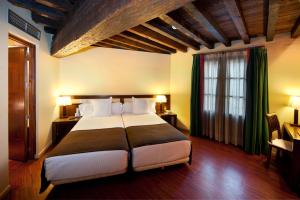 - une chambre avec un grand lit et une fenêtre dans l'établissement Abad Toledo, à Tolède