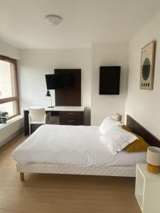 a bedroom with a white bed and a desk at Apparteo Strasbourg in Strasbourg