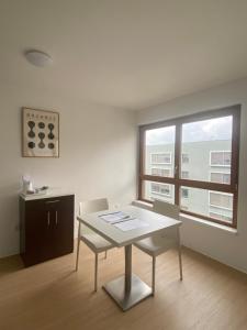a white table and chairs in a room with a window at Apparteo Strasbourg in Strasbourg