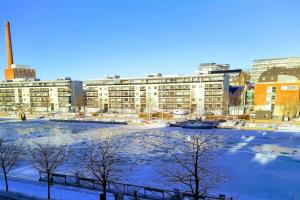 a frozen river in front of a large building at Föri condo, sauna and parking in Turku