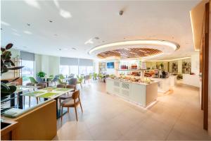 a restaurant with a cafeteria with tables and chairs at Hilton Garden inn Dubai Jumeirah in Dubai