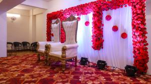 a wedding altar with two chairs and red flowers at Tuliip Residency in Mumbai