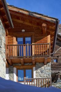 a balcony on the side of a log house at MCX Vacation Rental - MAISON LOZ Duplex in villaggio tipico Valdostano con comfort moderni e panorama mozzafiato in Valtournenche