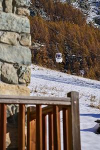 a bus on a ski lift over a snow covered field at MCX Vacation Rental - MAISON LOZ duplex in typical village in Valtournenche with modern comforts just 2 minutes from the cable cars! in Valtournenche