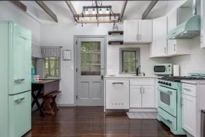 a kitchen with white cabinets and green appliances at The Biddle House by AvantStay Breathtaking Views Walk to Lake in Lake Harmony