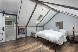 a bedroom with a white bed and a wooden floor at The Biddle House by AvantStay Breathtaking Views Walk to Lake in Lake Harmony