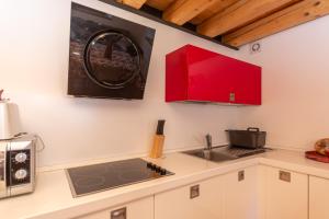 a kitchen with a sink and red cabinets at Appartamento Tre Valli 5 in Alleghe