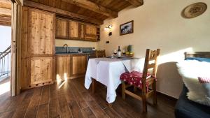 a kitchen with a table and a sink in a room at MCX Vacation Rental - MAISON LOZ duplex in typical village in Valtournenche with modern comforts just 2 minutes from the cable cars! in Valtournenche +19 photos