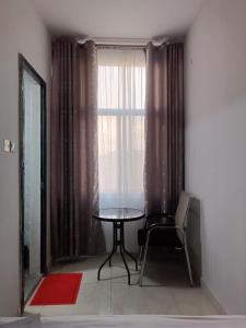 a table and a chair in a room with a window at Raya hotel juba in Juba +7 photos