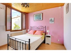 ein Schlafzimmer mit einem Bett mit einer rosa Wand in der Unterkunft City Cottage le Montreuillois in Montreuil