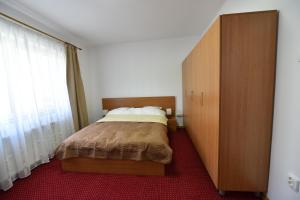Un dormitorio con una cama y un armario de madera. en Marcos Studio Apartment, en Bucarest 5 fotos más