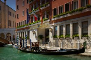 a gondola in the water in front of a building at Papadopoli Hotel Venezia - MGallery Collection in Venice