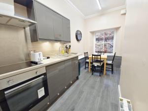 a kitchen with a counter and a table with chairs at Edinburgh Backpackers - over 18s only in Edinburgh