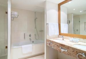 a bathroom with a sink and a shower and a tub at Holiday Inn Nürnberg City Centre, an IHG Hotel in Nuremberg