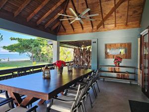 a dining room with a table and chairs and a ceiling fan at Villa Fantasy private beach and private pool in Rio Bueno