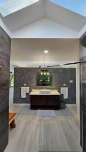 a large bathroom with a sink and a mirror at Villa Fantasy private beach and private pool in Rio Bueno