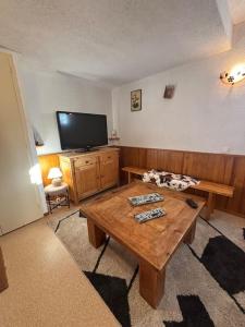 a living room with a wooden table and a flat screen tv at Appartement 4 personnes Châtel in Châtel