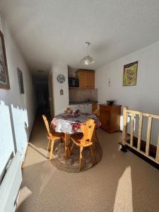 a kitchen with a table and chairs in a room at Appartement 4 personnes Châtel in Châtel +3 photos