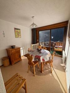 a dining room with a table and chairs and a window at Appartement 4 personnes Châtel in Châtel