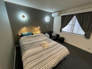 a bedroom with a bed with two towels on it at Restmance Pension Woody Hill in Iiyama