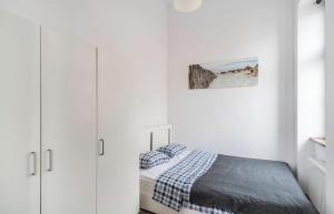 biała sypialnia z łóżkiem i białymi szafkami w obiekcie Apartament z osobną sypialnią w pięknej kamienicy w centrum we Wrocławiu