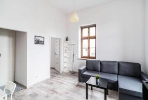 salon z kanapą i stołem w obiekcie Apartament z osobną sypialnią w pięknej kamienicy w centrum we Wrocławiu