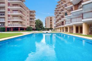 ハベアにあるJavea Brisas Del Mar Cofisaの一部のアパートメントビルの前にスイミングプールがあります。