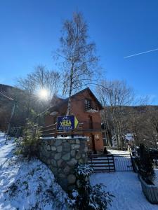a building with a sign on it in the snow at Brezovice Villa Vesa in Prevallë
