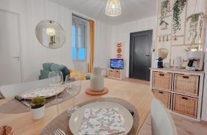 a living room with a dining room table with wine glasses at Le Petit Polinois in Poligny