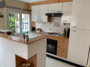 a kitchen with white cabinets and a stove top oven at Bray-Dunes avec jardin - 3chambres in Bray-Dunes