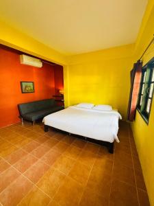 a bedroom with a white bed and a couch at Moondance Cottage Inn in Ko Chang