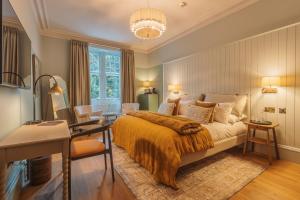 ein Schlafzimmer mit einem Bett, einem Tisch und einem Schreibtisch in der Unterkunft Pine Trees Hotel Pitlochry in Pitlochry