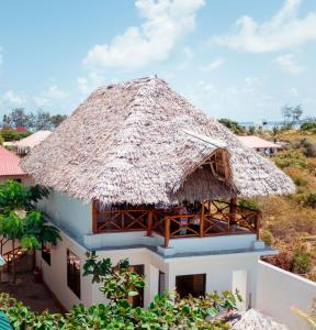 una casa con il tetto di paglia di Makazi Garden Villas a Zanzibar City