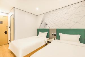Postel nebo postele na pokoji v ubytování Qingji Hotel mini Beijing Wangfujing Dengshikou Subway Station Branch