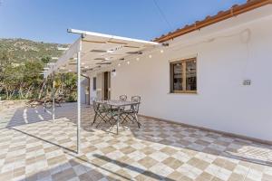 a patio with a table and chairs under a pergola at Casa Marea in Marina di Gairo +8 photos
