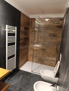 a bathroom with a toilet and a glass shower at Hotel Orchidea in Passo del Tonale +47 photos