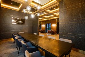 a conference room with a long wooden table and chairs at The Upper House, Batu Kawan in Batu Kawan +92 photos