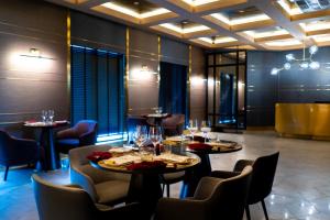 a restaurant with tables and chairs with wine glasses at The Upper House, Batu Kawan in Batu Kawan