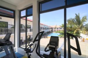 a gym with two elliptical machines and a view of a pool at Canary Hotel & SPA in Nungwi