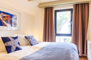 a bedroom with a bed and a large window at Wellness- FeWo "Akelei" mit Sauna & Kamin in Zingst
