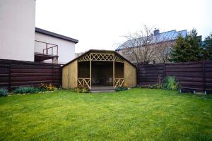 a house with a large screened porch in a yard at Garden Cottage in Šiauliai