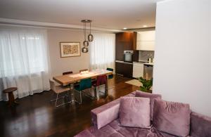 a living room with a purple couch and a table at Garden Cottage in Šiauliai