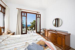 ein Schlafzimmer mit einem Bett mit einer Kommode und einem Fenster in der Unterkunft Villa Ariadne in Argaka + 46 Fotos