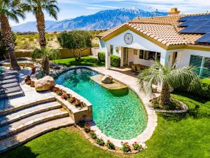 a backyard with a swimming pool and a house at Mini Golf, Saltwater Pool & Spa by MariamsBnb in Desert Hot Springs