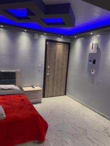 a bedroom with a red bed and a wooden door at MONASTHRIOY PALLAS 3 By MAKHOME in Thessaloniki
